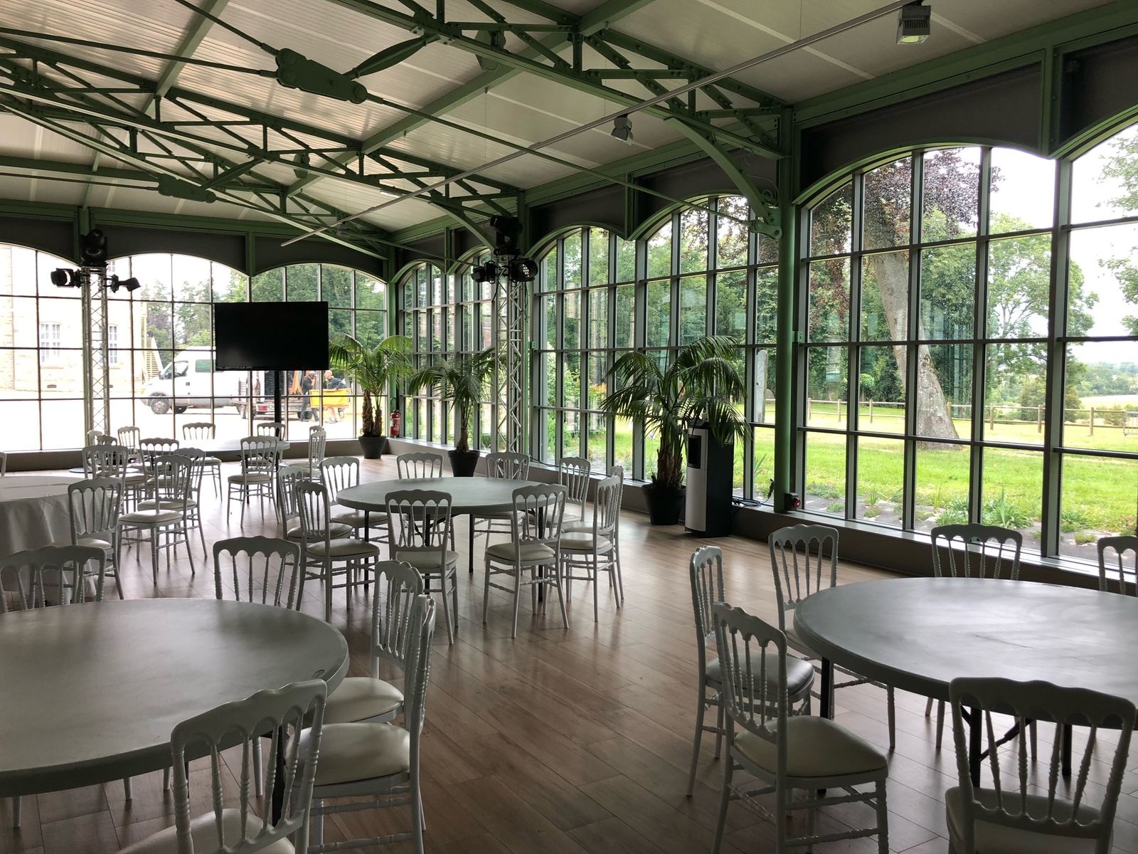 Salle de réception végétalisée avec palmiers devant une verrière